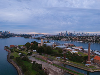 Panoramic drone aerial view over Sydney harbour on a cloudy sunset showing the nice colours of the harbour foreshore