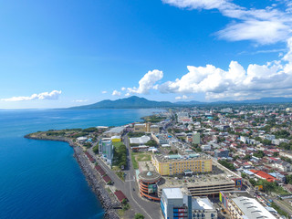 Manado Indonesia June 28, 2020 : Aerial skyscrapers marina in the sunny day with front line of...