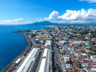 Obraz premium Manado Indonesia June 28, 2020 : Aerial skyscrapers marina in the sunny day with front line of office, home, urban city Manado Indonesia
