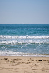 Fototapeta na wymiar Calm Waves Washing Over a Beach on a Sunny Day