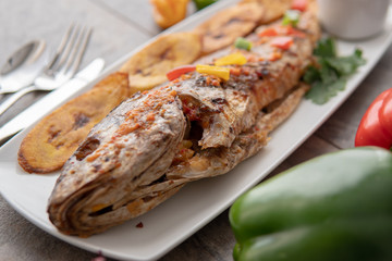 Grilled fish curry with plantain and salad. African national dish. Nigerian fish curry. Healthy lifestyle meal. Vegetarian food