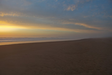Fototapeta na wymiar Sunrise view of beach against cloudy sky in Portugal