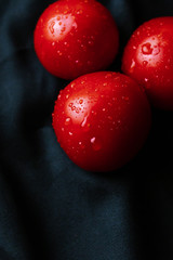red tomatoes with water droplets on a dark background