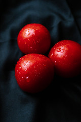 red tomatoes with water droplets on a dark background