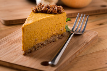 Pumpkin Pie with raw granola crust on wood with fork