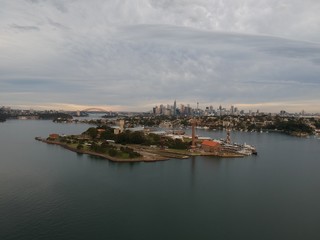 Fototapeta na wymiar Panoramic drone aerial view over Sydney harbour on a cloudy sunset showing the nice colours of the harbour foreshore
