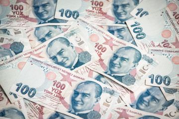 Obraz premium Many hundred Turkish lira on wooden table background texture. bundles of money scattered on the office desk. wealth and income concept. Counting money. 