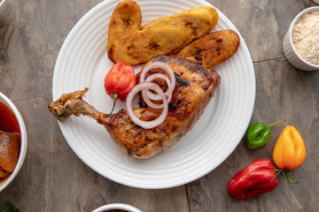 African national food dish grilled meat and chicken dish wings home-made Cuisine with plantain with jollof rice. Nigerian Jolofrice. Grilled African fish dish and meal with chilli banana and plantain.