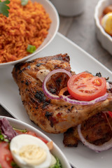 African national food dish grilled meat and chicken dish wings home-made Cuisine with plantain with jollof rice. Nigerian Jolofrice. Grilled African fish dish and meal with chilli banana and plantain.
