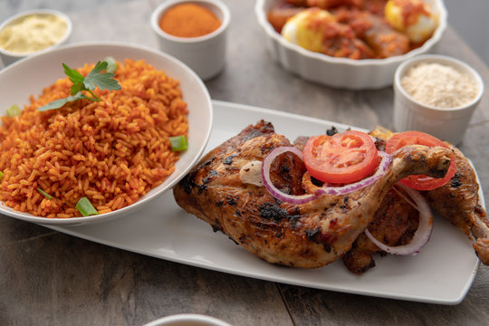 African national food dish grilled meat and chicken dish wings home-made Cuisine with plantain with jollof rice. Nigerian Jolofrice. Grilled African fish dish and meal with chilli banana and plantain.
