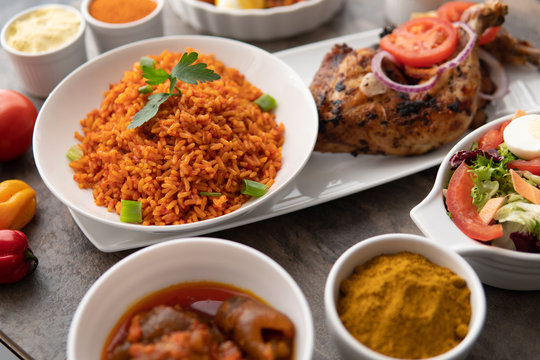 African national food dish grilled meat and chicken dish wings home-made Cuisine with plantain with jollof rice. Nigerian Jolofrice. Grilled African fish dish and meal with chilli banana and plantain.
