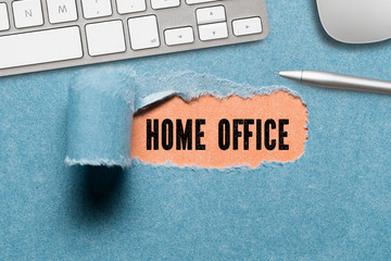 torn paper revealing message HOME OFFICE surrounded by office items on paper background