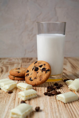 cookies with chocolate and milk on a light wooden table
