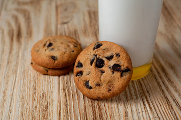 cookies with chocolate and milk on a light wooden table