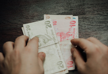 Many hundred Turkish lira on wooden table background texture. bundles of money scattered on the office desk. wealth and income concept. Counting money. 