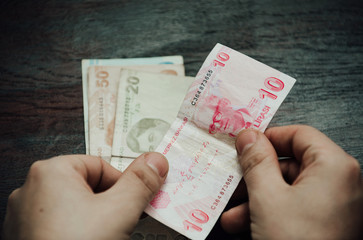 Many hundred Turkish lira on wooden table background texture. bundles of money scattered on the office desk. wealth and income concept. Counting money. 