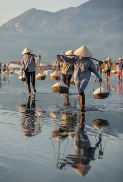 Salt and Silhoutte of salt farmer on salt field Hon Khoi, Nha Trang, Khanh Hoa, Vietnam.