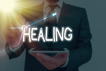 Conceptual hand writing showing Healing. Concept meaning process of making or becoming sound or...
