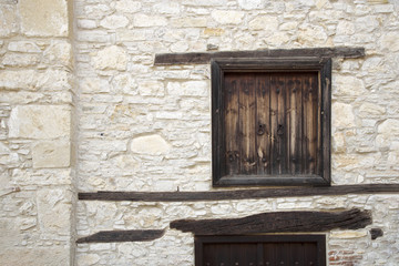 Fancy wooden windows in the stone wall of the Cypriot village of Omodos