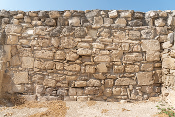 Wall of the medieval castle of Kolossi with soil and a piece of blue sky (Cyprus).