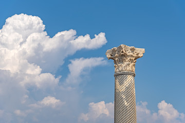 Antique column against the blue skies with a cloud in the ancient city of Kourion (Cyprus)
