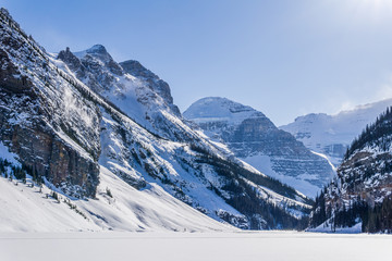 Fototapeta na wymiar rocky mountains around frozen lake louise winter wonderland.