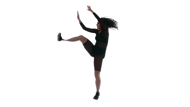 silhouette of a young beautiful girl in a black transparent tight suit energetically dancing dancehall, street dance, twerk against white background