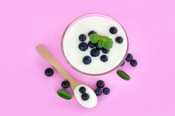 Close up yogurt with fresh blueberries  fruit in glass bowl  on pink backgroun