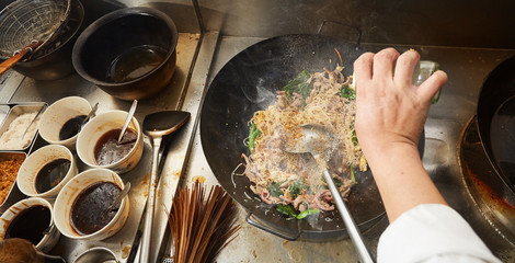 Chef stir fry cooking on top view