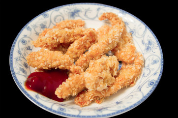 The fried chicken fillet and ketchup in a  blue and white porcelain dish.
