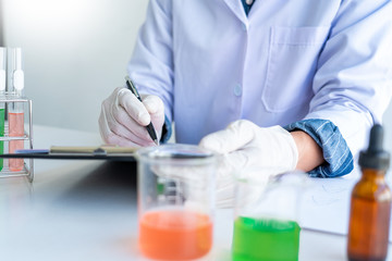 Fototapeta premium Scientist wear lab coat and protective wear are working with research or doing investigations with test tubes in experiment, Laboratory and development concept