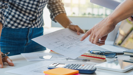 Cooperation Corporate designers in the office are working on a new project Planning blueprint Design at construction site at desk in office.