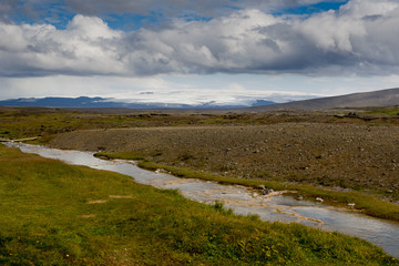 Beautiful colourful Icelandic landscape lava fields mountain geysers zigzag road and moss-covered...