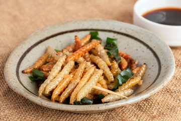 Food Insects: Bamboo worm or Bamboo Caterpillar insect deep-fried crispy for eating as food items in plate on sackcloth, it is good source of protein edible for future food. Entomophagy concept.