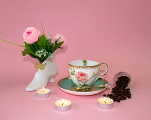 .coffee, flowers, candles on a pink background as a symbol of home warmth and coziness, beauty and a wonderful morning breakfast