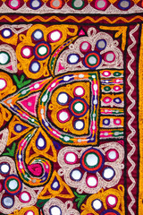 embroidered good like old handmade cross-stitch ethnic Indian pattern,embroidery design and pattern art with colorful handmade fabric,embroidery ethnic flowers neck line flower design ,selective focus