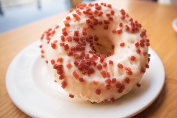 close up of two big white donuts with strawberry jellies on a white plate in a coffee cafe