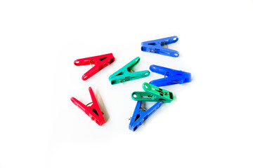 Many different colored plastic clothes pegs isolated on white background.