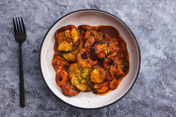 plant-based food, vegan aubergine zucchini bake with tomatos and nutritional yeast topping