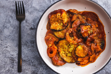 plant-based food, vegan aubergine zucchini bake with tomatos and nutritional yeast topping