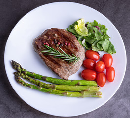 Steak on a white plate with vegetables