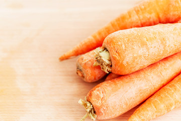 A bunch of fresh clean carrots on a wooden board. Close-up. Space for text. Healthy lifestyle and vegetarianism. Top view.