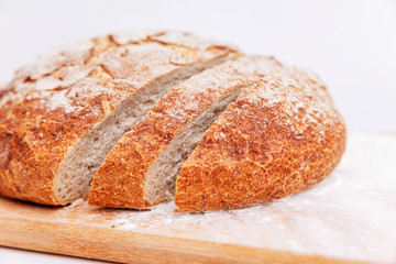 Sliced fresh round bread on a wooden cutting board. Homemade baking. Close-up.
