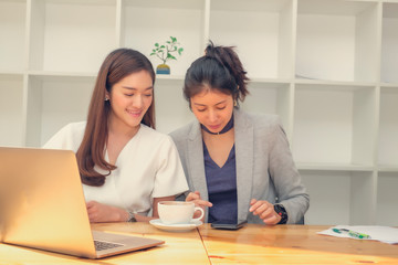 Fototapeta premium Asian business woman working in co-working space, online meeting, working in small team and brainstorming