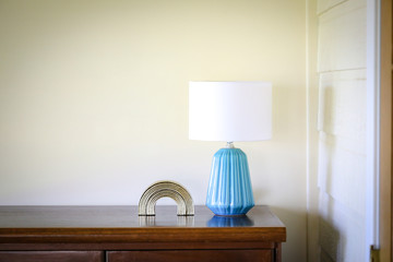 Vibrant blue lamp with gold paper weight statue, basic interior image with copy space