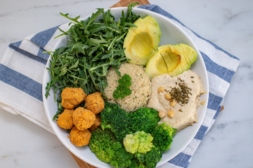Vegan lunch bowl with quinoa, hummus, chickpeas, avocado, vegetables