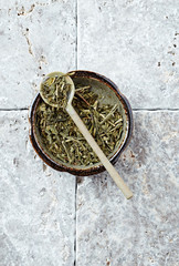 Dried Green Tea Leaves on rustic stone Background. Top view. Copy space.