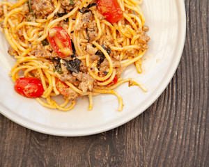 Spaghetti bolognese with tomato, cheese and basil on a plate