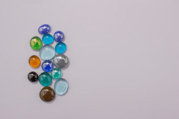 Abstract art design background of colorful glass drop dragon tears on a light neutral background with copy space