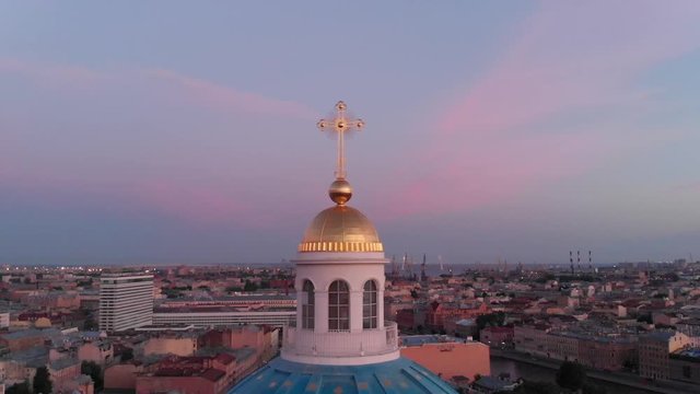 A seagull flies above the Trinity Cathedral at sunrise, by drone in Saint Petersburg, Russia
